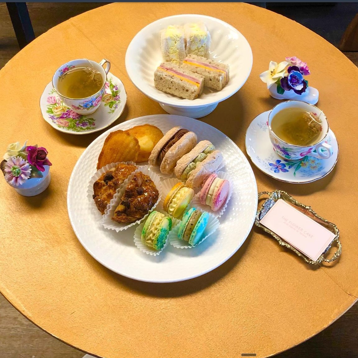 Afternoon tea with macarons, sandwiches and vintage teacups