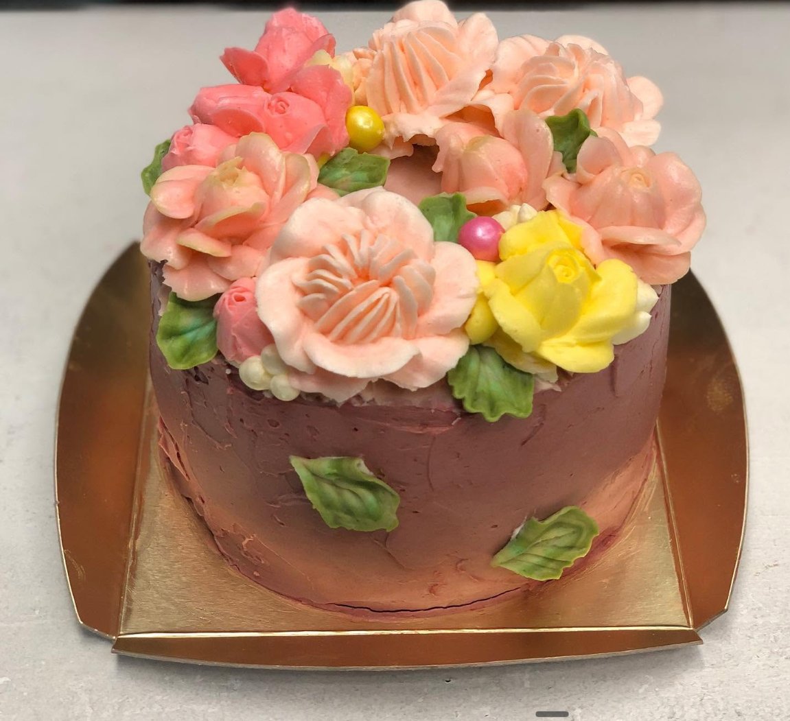 Mauve cake with pink and yellow buttercream flowers