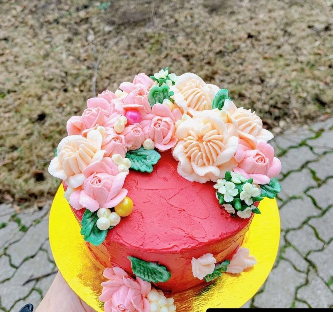 Pink cake topped with pale pink buttercream flowers