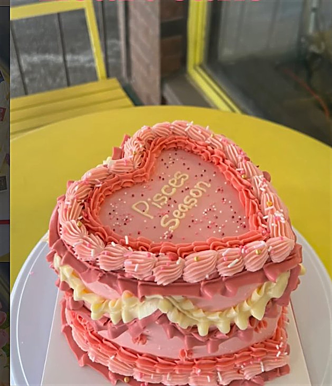 A pink vintage heart cake with piped shell borders