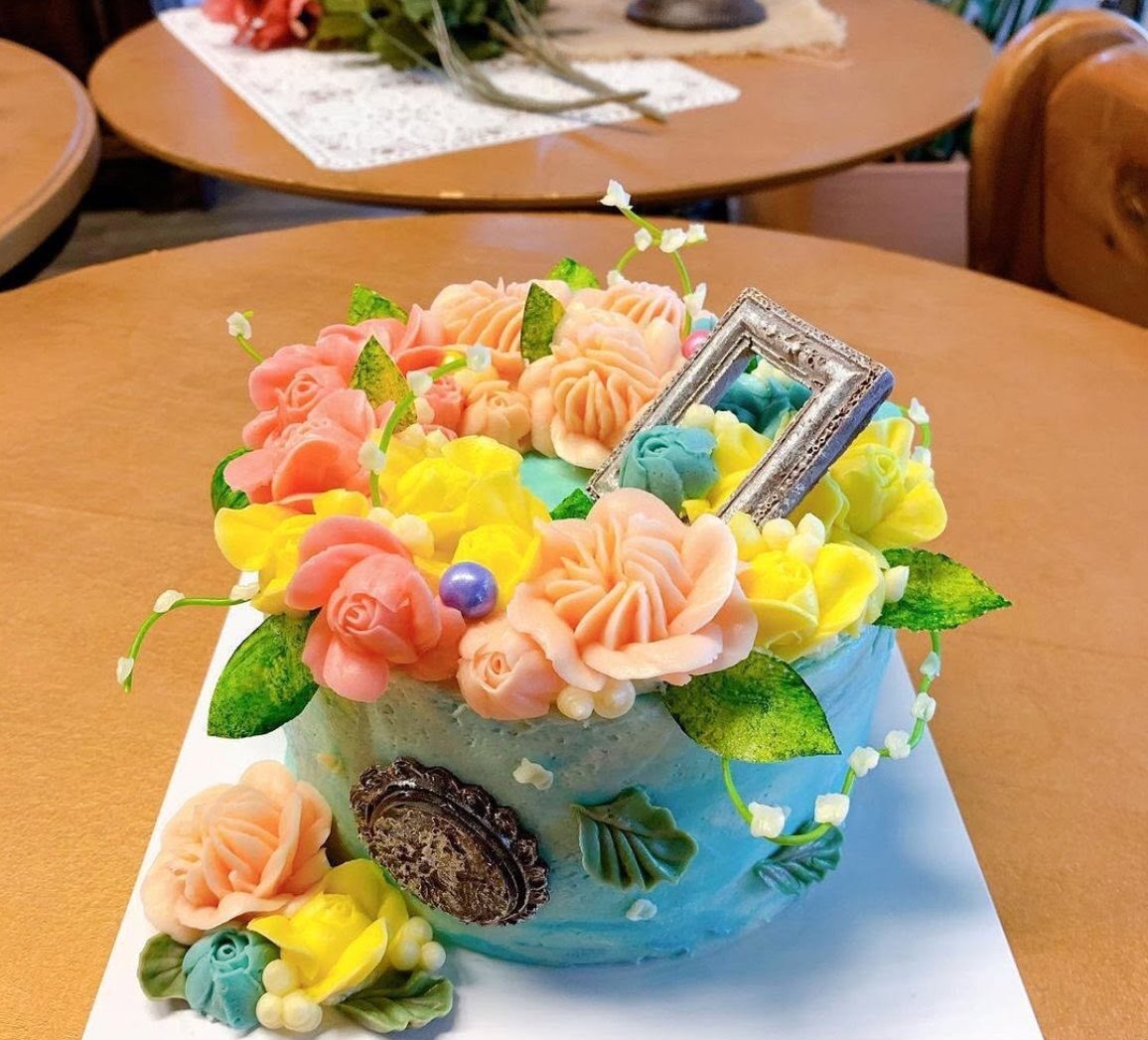 A turquoise flower cake on a café table