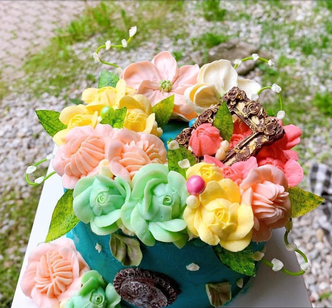Turquoise buttercream cake with pink, yellow and green piped flowers